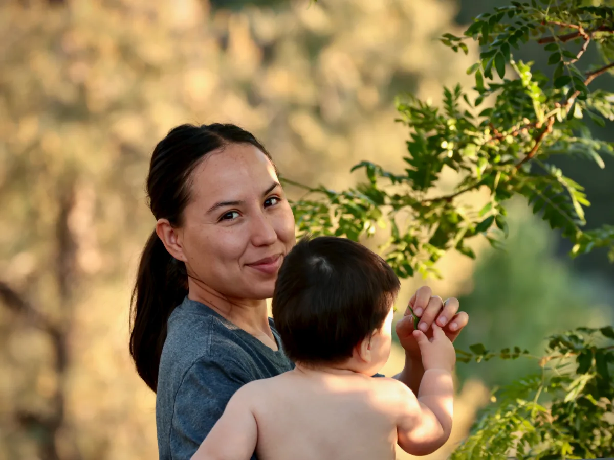 My wife and our son looking at leaves on a tree